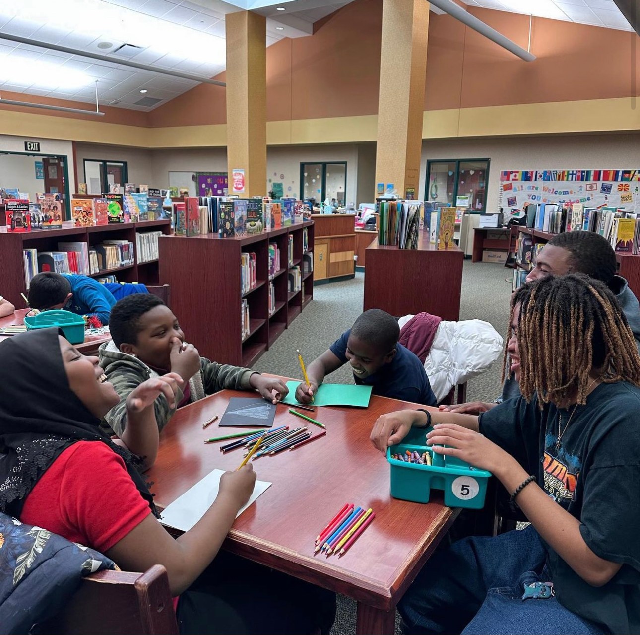 A Learn Like Me tutoring session around tables in an elementary school library