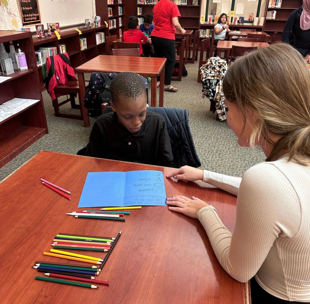 A Learn Like Me tutor working one-on-one with an elementary student in the school library